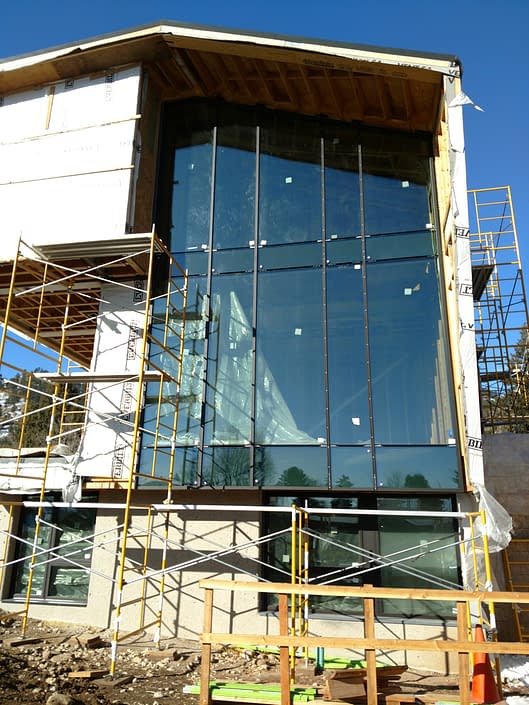 Scaffolding is used to aid in the installation of the oversized glass for these steel windows.