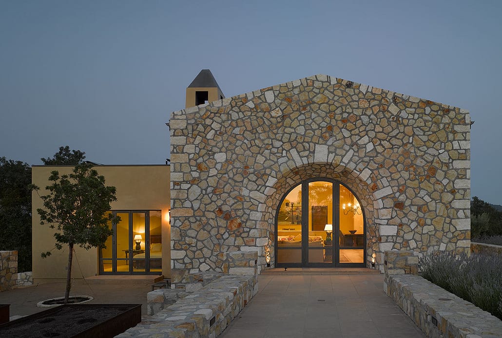 Bronze windows and doors by Brombal work in harmony with the stone and stucco exterior