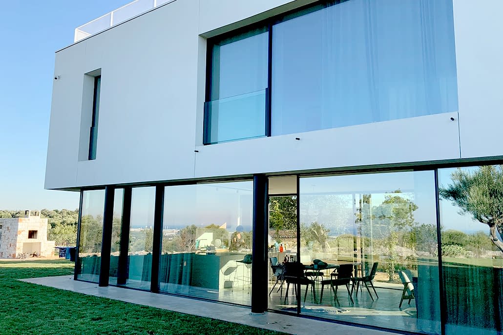 A minimal frame lift slide door system by Contempo Vista expands the living space to the outdoor lounge area