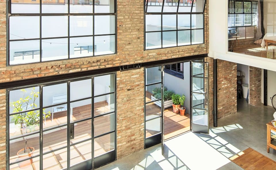 Hot rolled steel door and window systems flood this loft with natural light