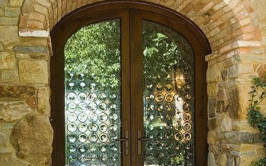 Custom arched wood entryway door with textured glass insets