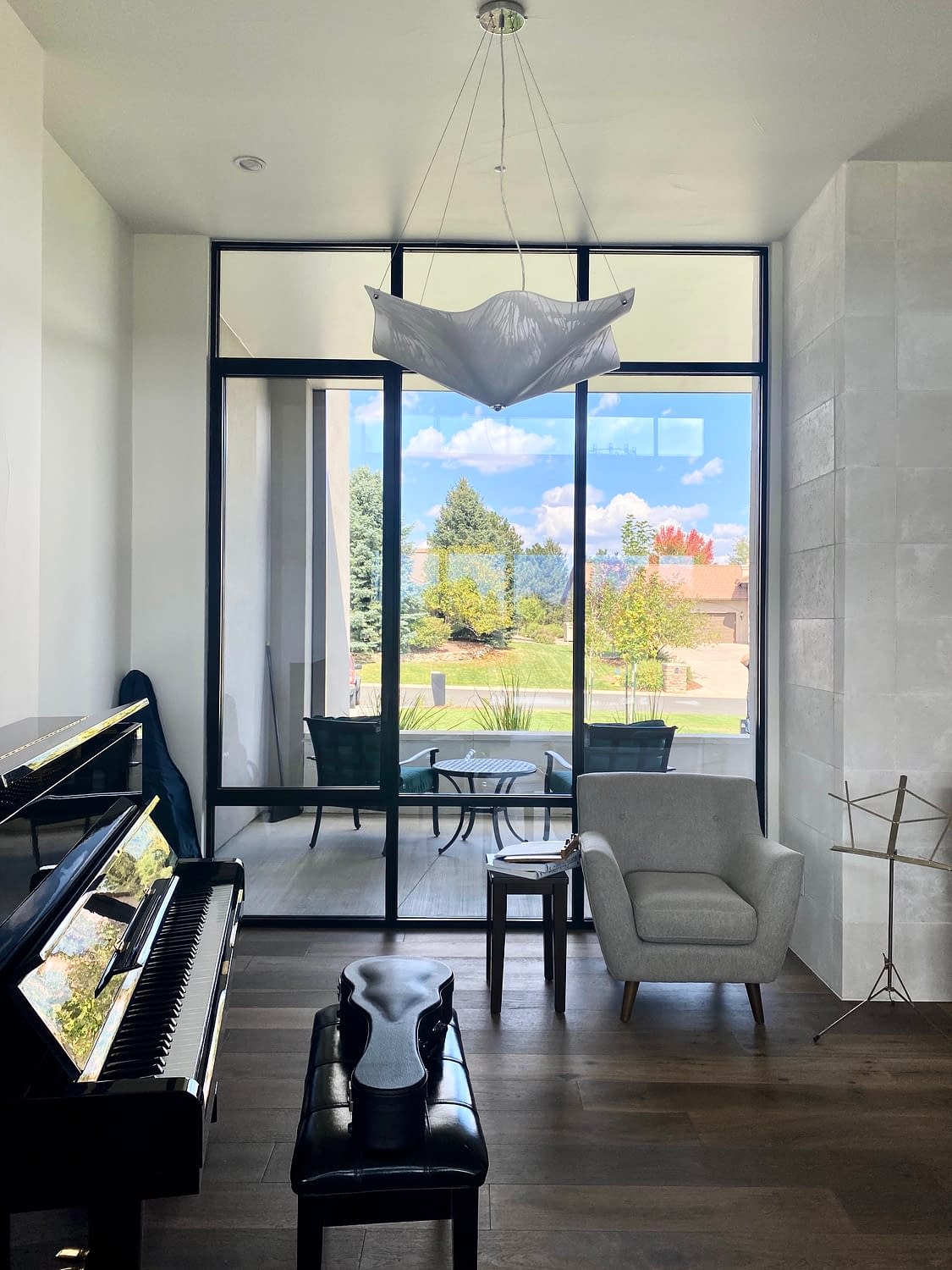 A combination of fixed and operable floor to ceiling aluminum windows floods the music room with natural light.