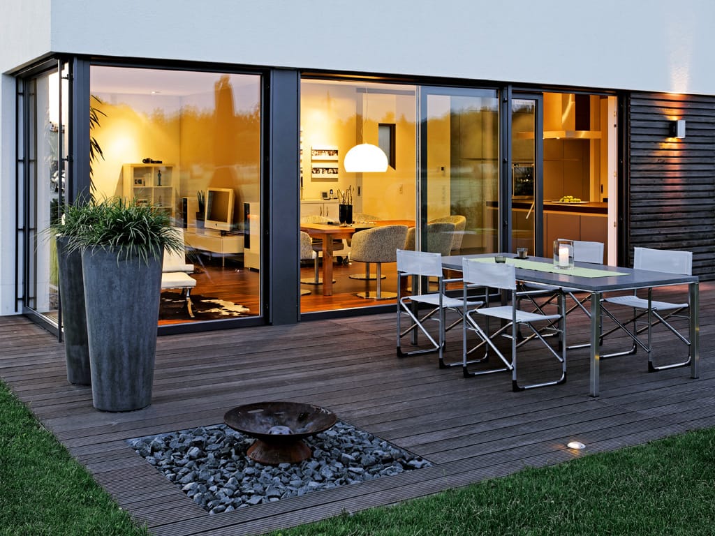 A PVC sliding door from SPI Finestre expands the living space to the outdoor lounge.