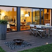 A PVC sliding door from SPI Finestre expands the living space to the outdoor lounge.