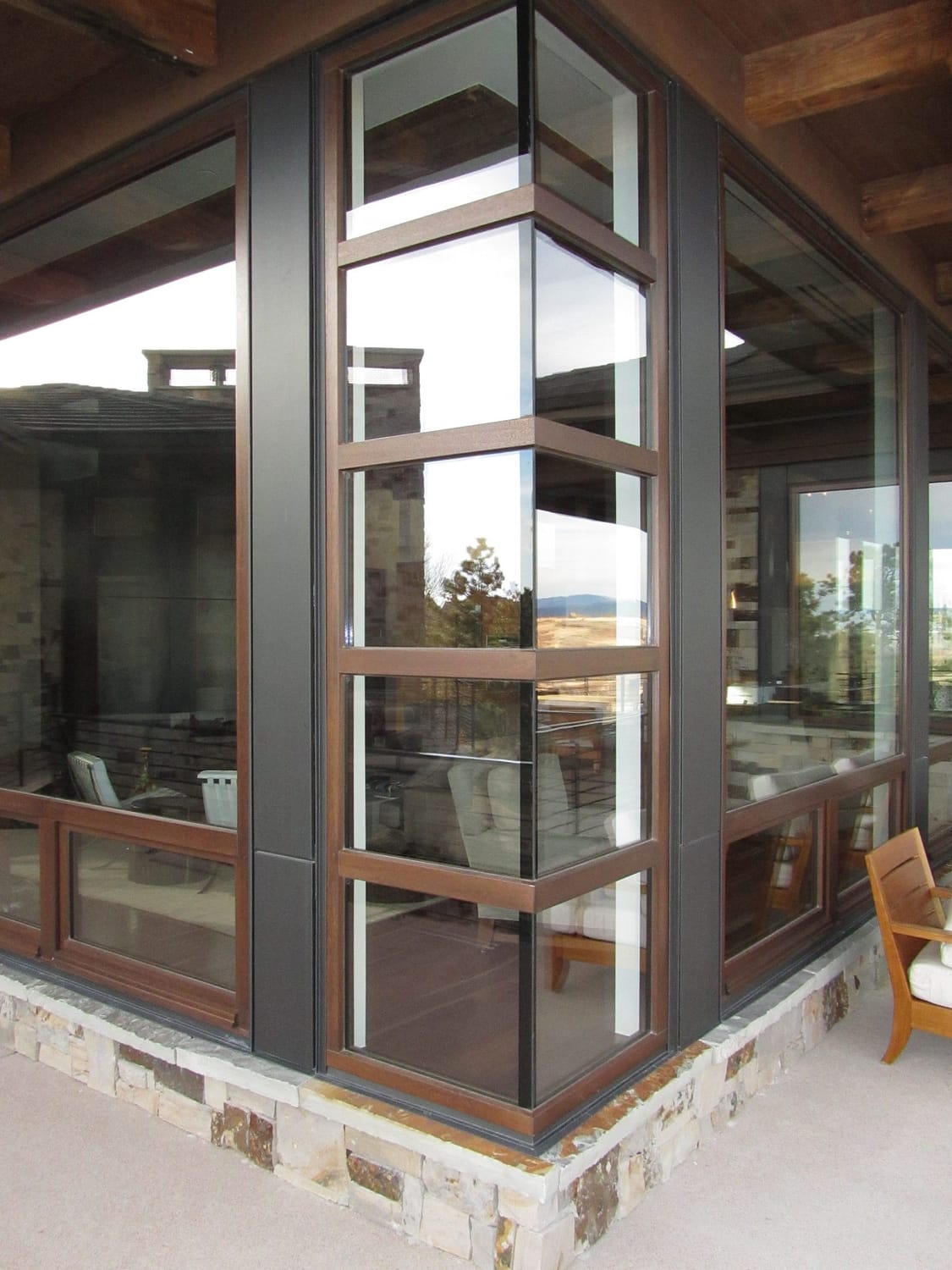 A custom corner meet wood and bronze window by Veranda View