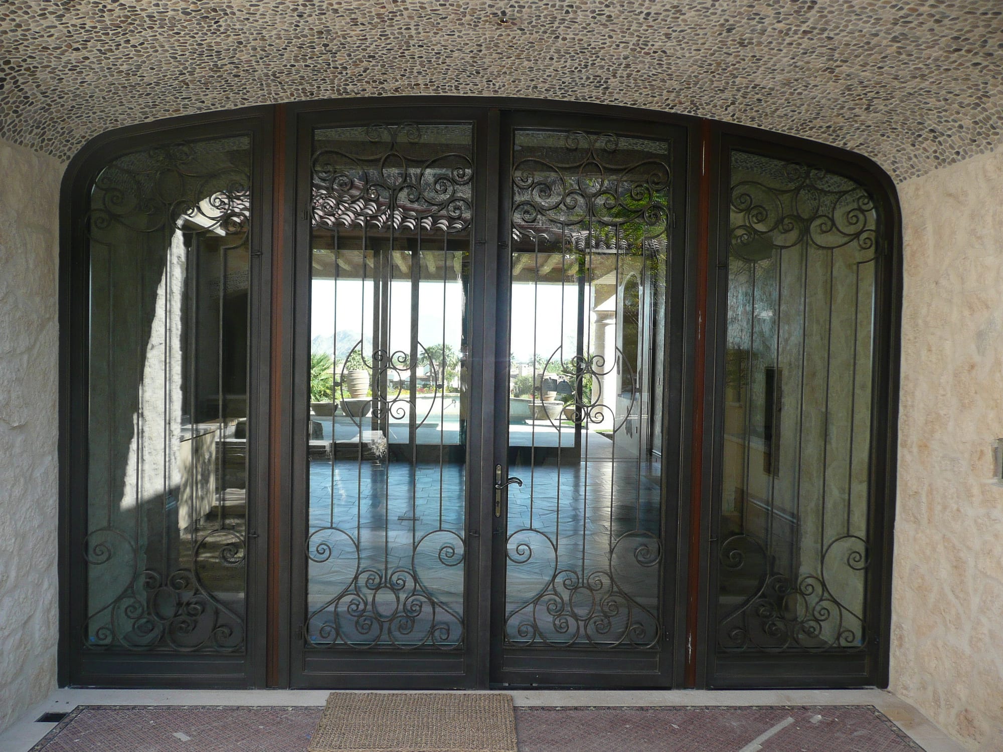 An oversized decorative arched steel entryway door
