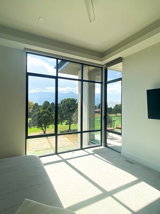 This bedroom features floor to ceiling fixed and operable aluminum windows from SPI Finestre.