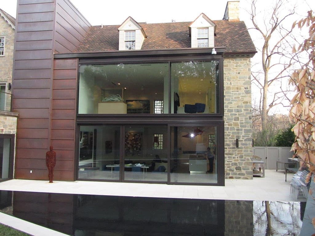 Expansive glass windows and lift slide door in bronze showcase this contemporary home