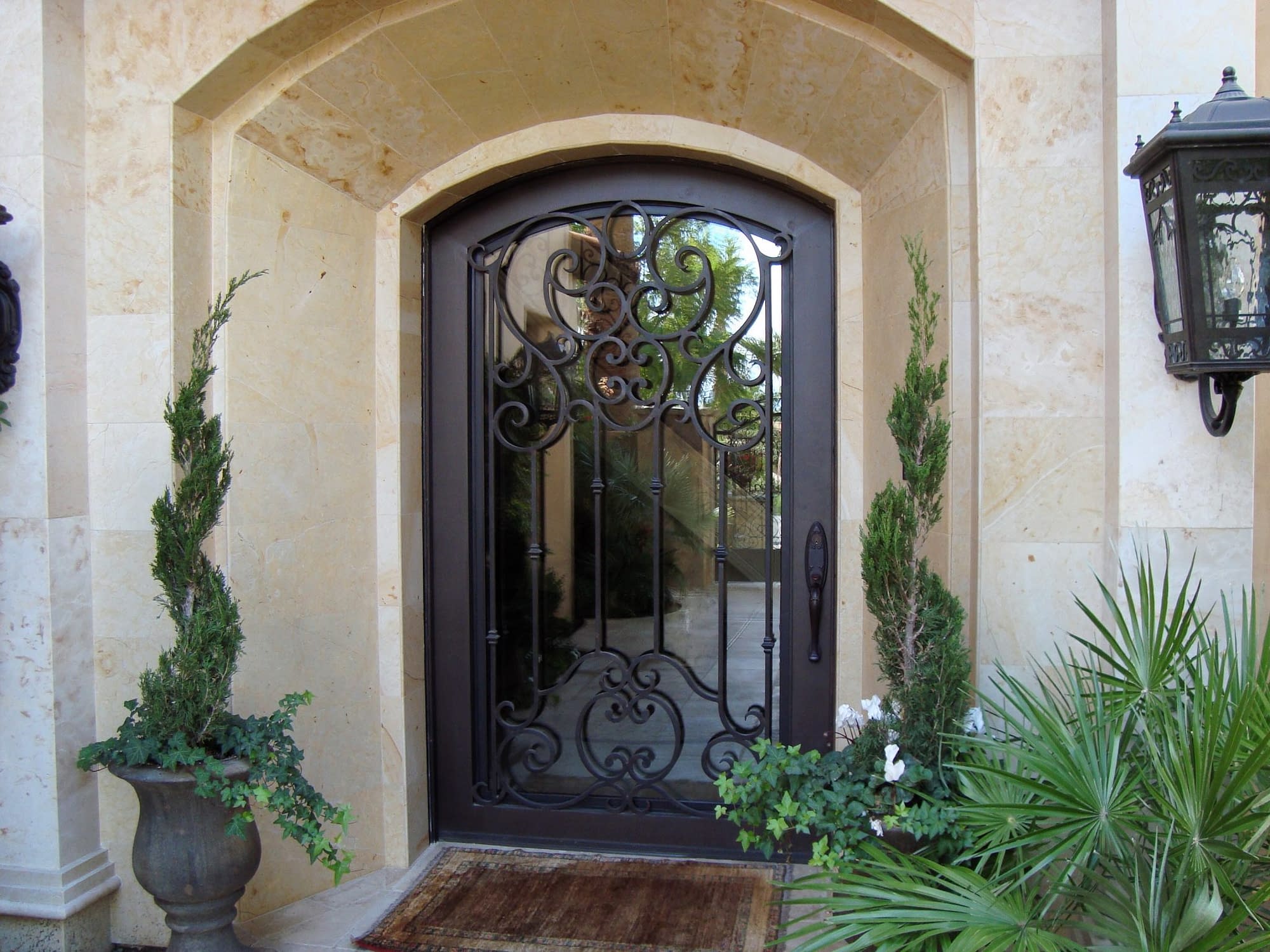 An arched iron entryway door with scroll detail