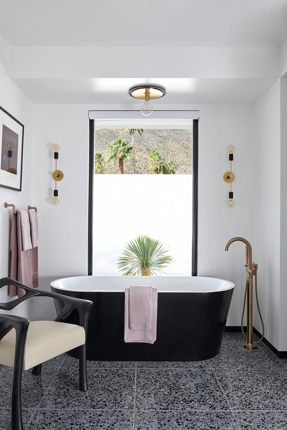 an oversized minimal frame aluminum window floods the bathroom with natural light