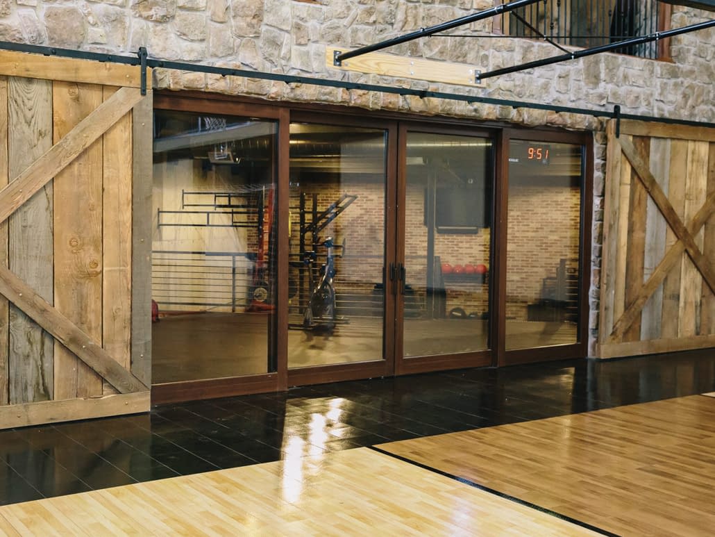 A lift slide door separates the gym from the workout room. Materials: wood