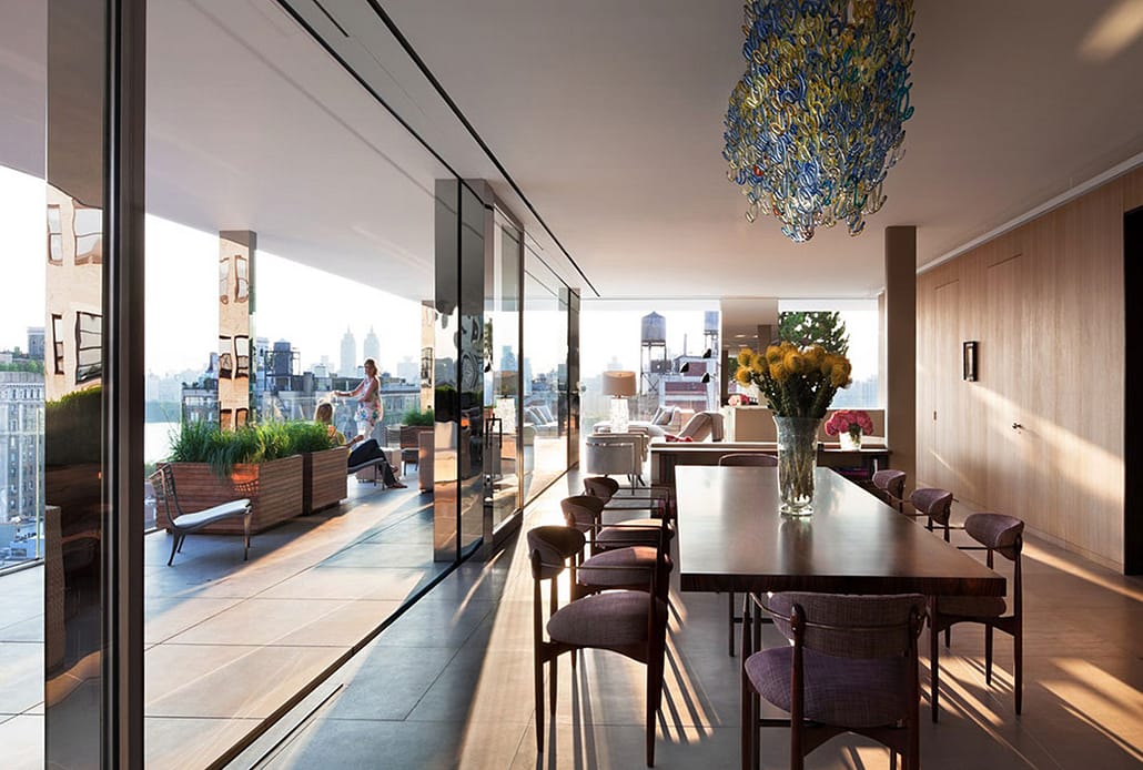 Minimal frame stainless steel windows and doors with expansive glass creates glass walls with views of the city