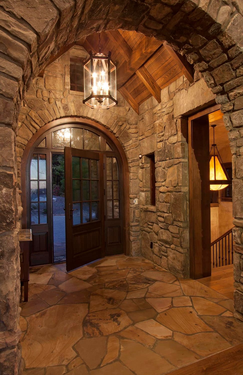 Arched wood and glass entryways by Veranda View is flanked by side windows and an arched transom