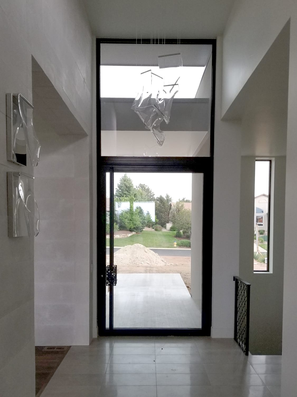 A glass pivot door below and a large fixed window above complete this glass wall.