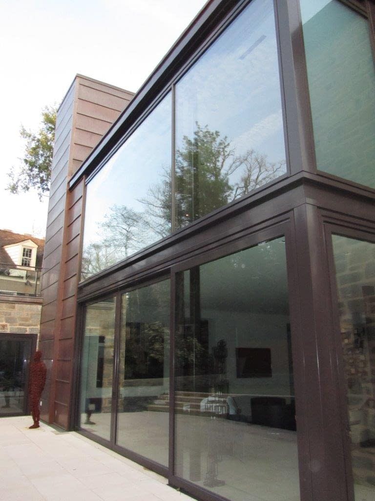 Expansive glass window systems and lift slide door in bronze showcase this contemporary home