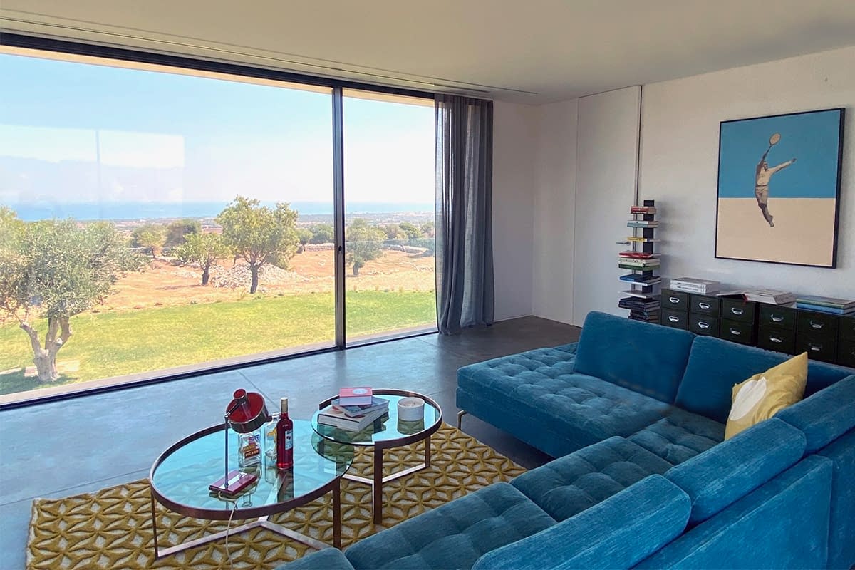 An expansive minimal frame window and door from Contempo Vista gives the homeowner views of the ocean while relaxing