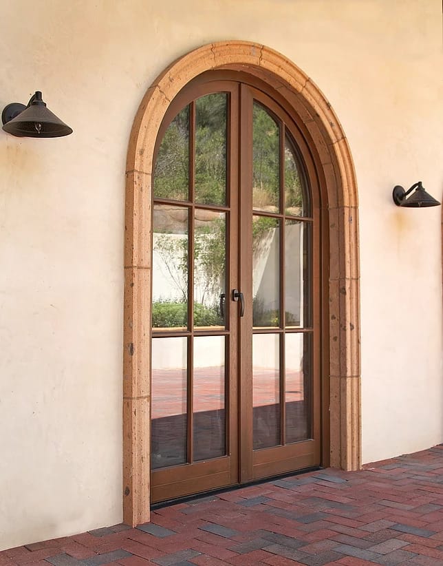 Tuscan style entryways are our specialty like this wood double door with narrow profiles