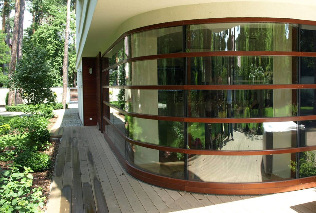 The front of this home features a custom curved wood curtain wall
