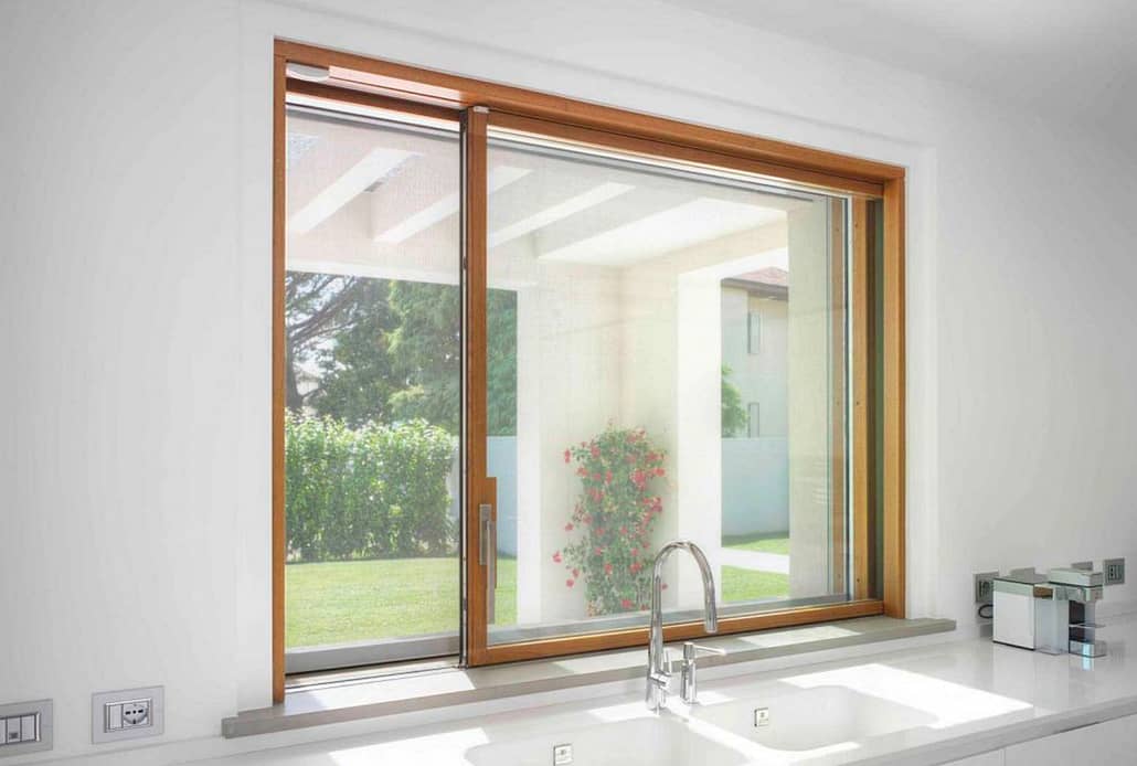 Carminati's minimal frame wood sliding window above the kitchen sink allows for unobstructed views of the backyard